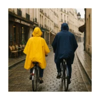 Cape de pluie vélo Badawin jaune et bleue portée par un couple à vélo, imperméables et pratiques pour cyclistes urbains.