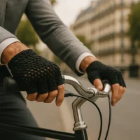 Zoom sur les mains d’un homme avec gants crochet noir, tenant le guidon