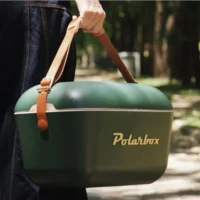 Glacière Polarbox Green Forest portée élégamment à la main.