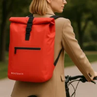 Femme utilisant un sac à dos vélo Ali rouge étanche Badawin rouge.Capacité 28L.