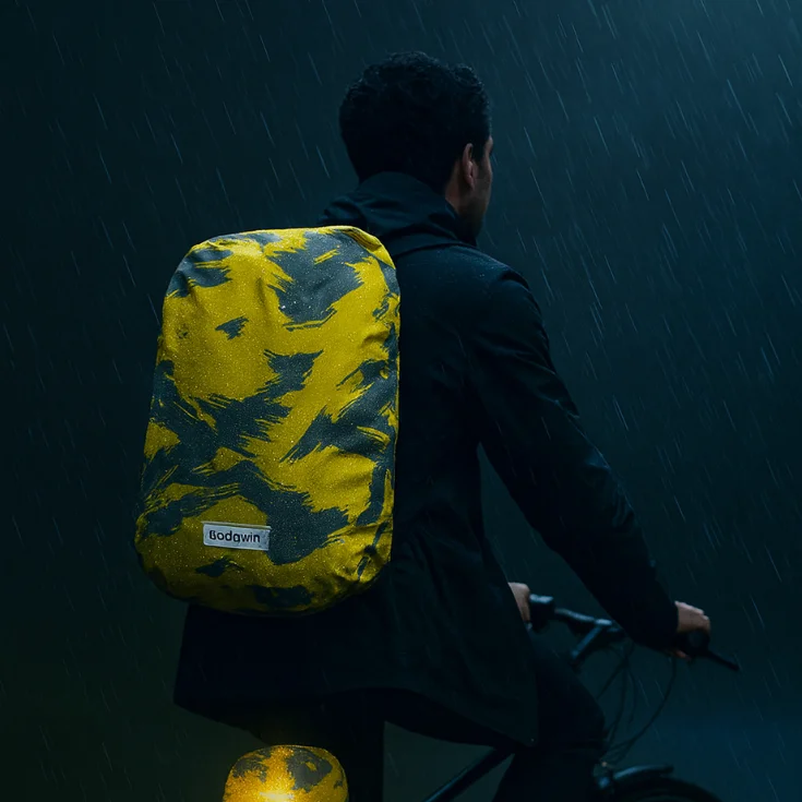 Cycliste sous la pluie avec housse de sac vélo réfléchissante jaune Badawin