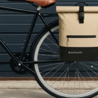 Sac à dos de vélo Badawin Anna sable fixé sur le porte-bagages d’un vélo noir