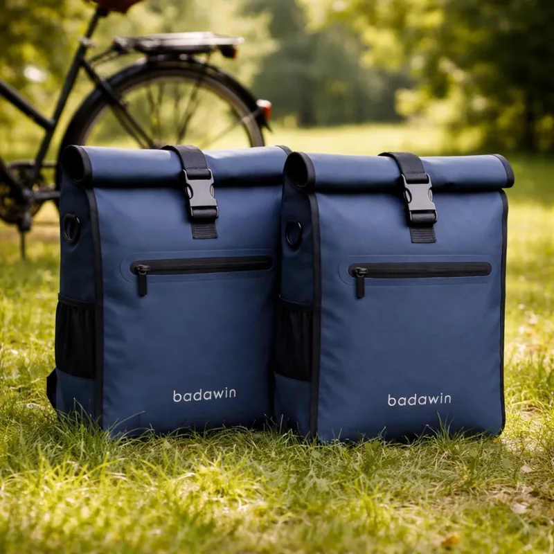 Lot de 2 sacoche vélo Aaron Badawin bleu marine posées côte à côte sur herbe.