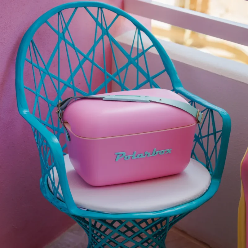 Glacière Polarbox Bubble Gum rose posée sur une chaise turquoise